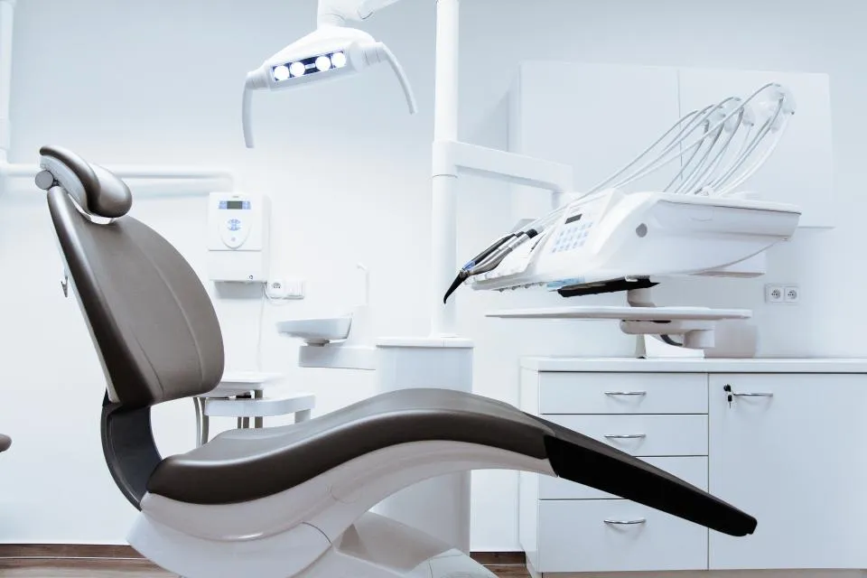 Empty modern dental surgery with a treatment chair and overhead light
